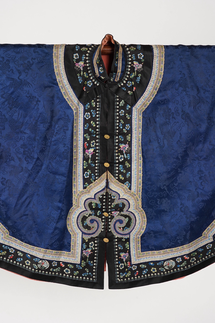 A late 19th century Chinese blue silk damask jacket, woven with Phoenix and auspicious symbols. The jacket edged with ornate rows of braiding and silk embroidery, the interior with original pink silk lining. The jacket f